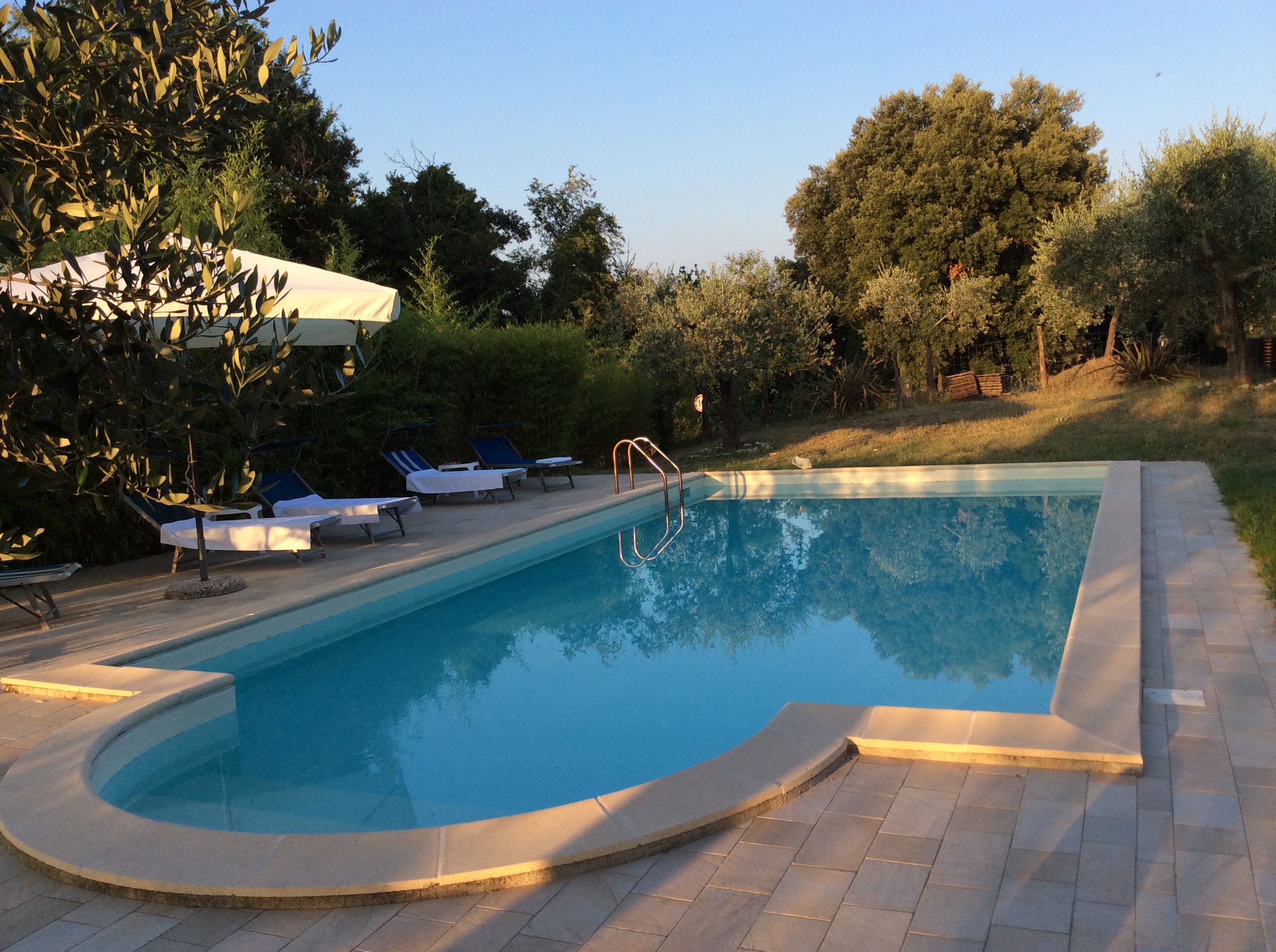 La piscina al tramonto, a disposizione degli ospiti, è immersa nel verde della Tenuta.